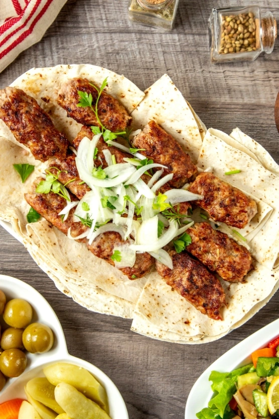 Al Aqsa Restaurant signature kebab platter with fresh onions and herbs, served on flatbread in Parkchester, Bronx
