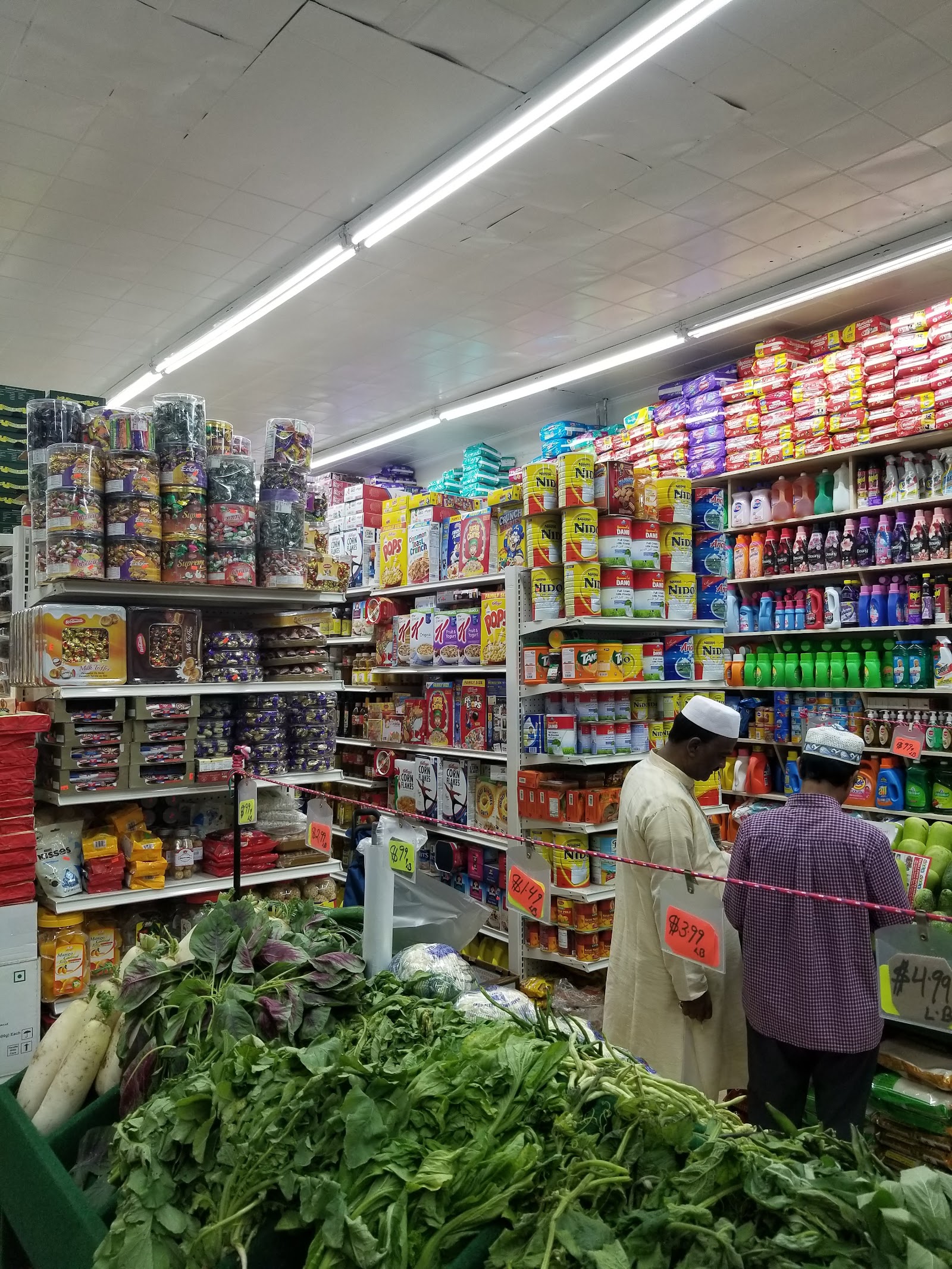 Bangla Town Supermarket interior with fresh produce, South Asian groceries, and shoppers in the Bronx